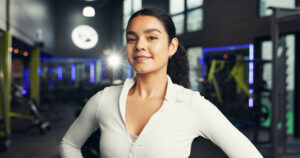 personal-trainer-fitness-woman-with-smile-gym-training-routine-workout-portrait-health-coach-athlete-happy-sports-club-about-us-confidence-wellness-ready-exercise